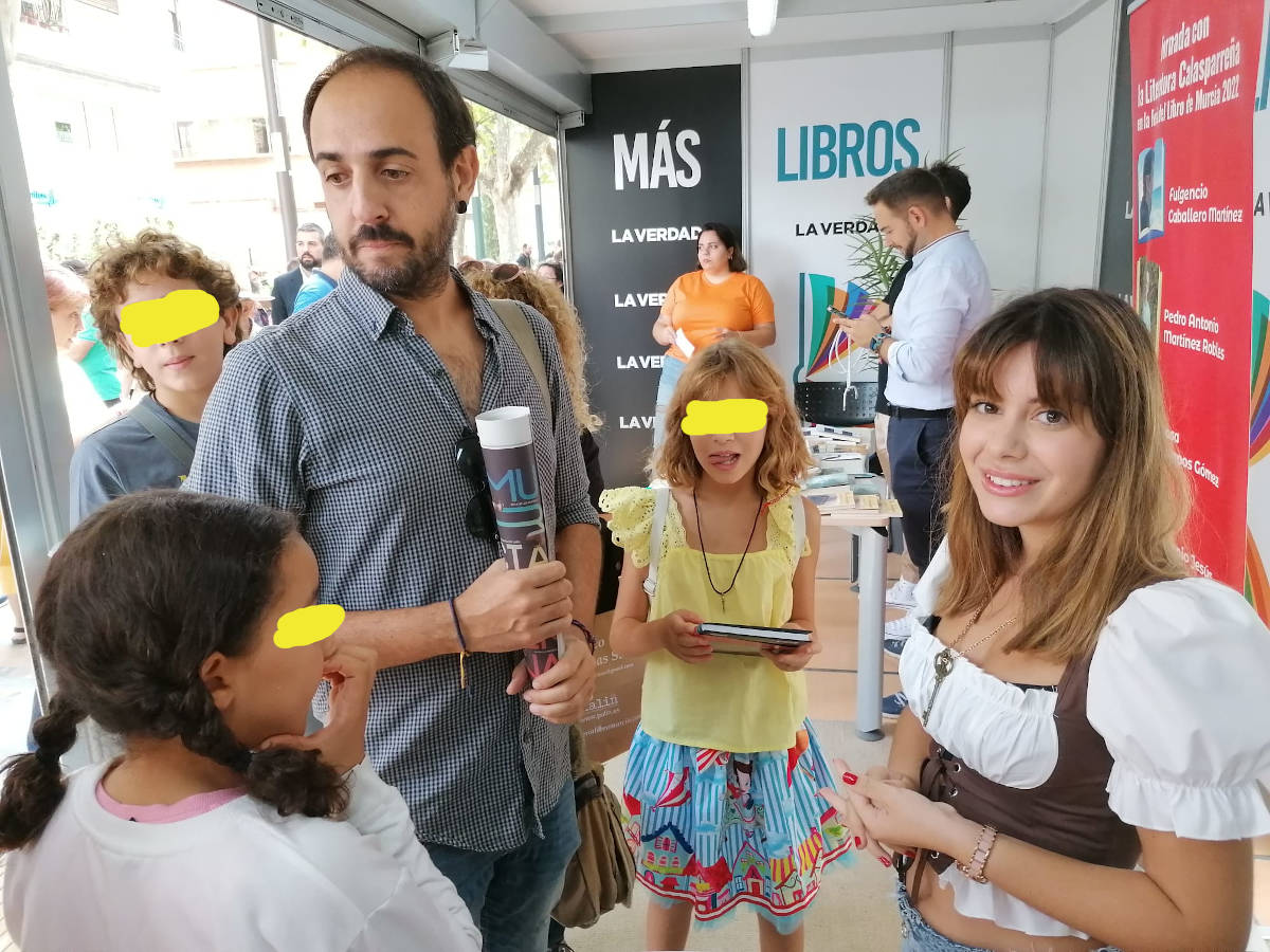 Autora y niños en la caseta de La Verdad de la Feria del libro de Murcia 2022, uno de los principales puntos de celebración de eventos, siempre lleno de vida