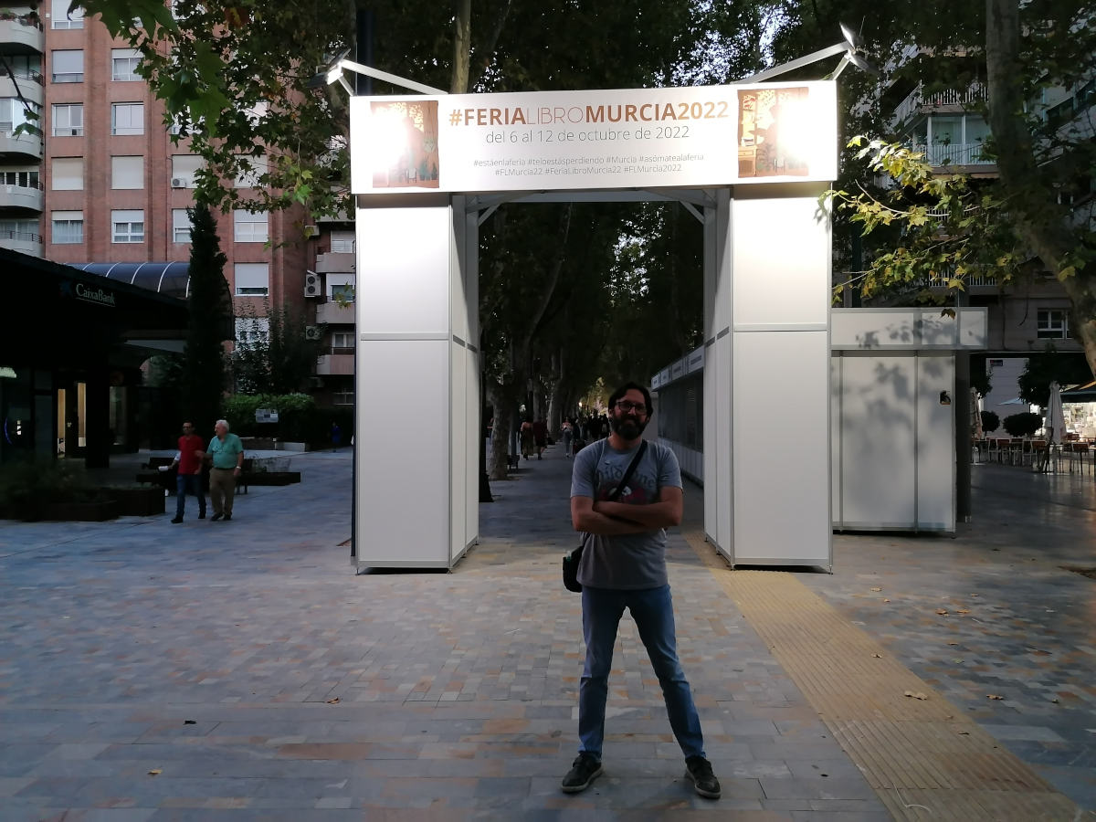 Sergio Reyes posa frente a una de las portadas aún sin terminar en la víspera de la inauguración de la Feria del libro de Murcia 2022