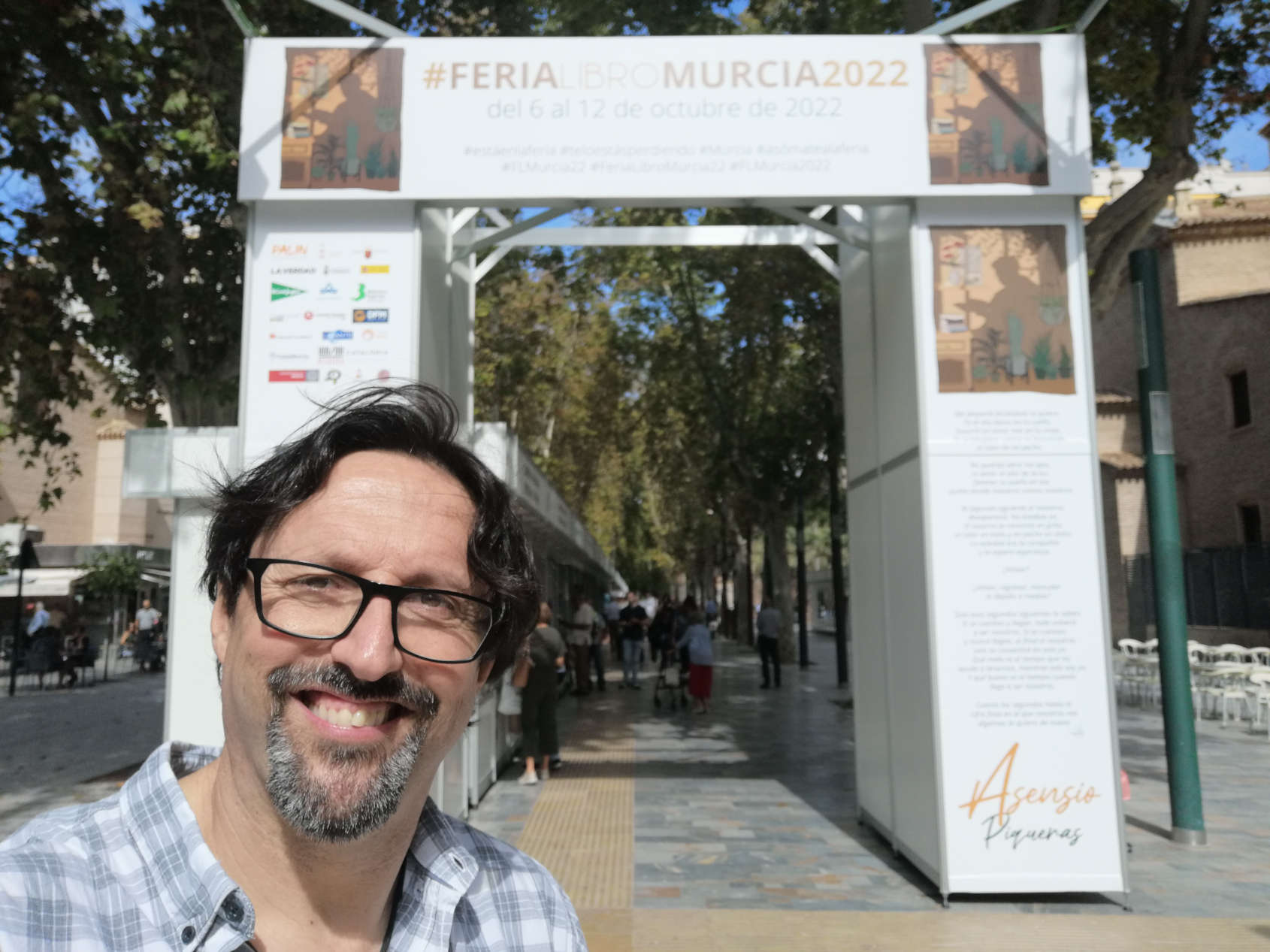 Sergio Reyes posa frente a otra de las portadas ya terminada a primerísima hora del comienzo de la Feria del libro de Murcia 2022