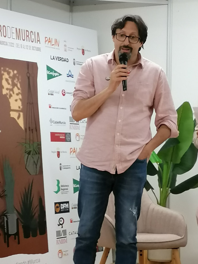 Sergio Reyes habla sobre el premio que le ha sido entregado en el acto de entrega de premios del concurso de relato corto JC por la Cultura promovido por Inmobiliaria Joaquín Cárceles en la Feria del libro 2022