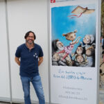 Sergio Reyes posa junto a la cartelería de la XXX Feria del libro de Murcia 2023