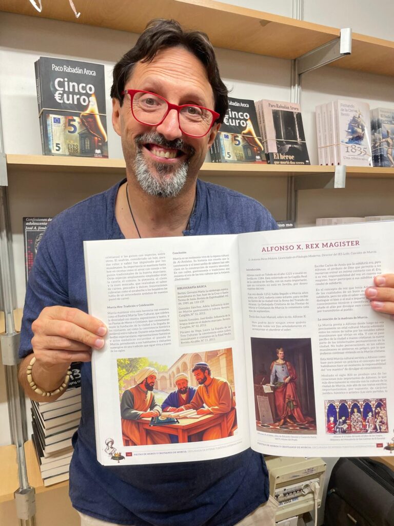 Sergio Reyes muestra la tercera página de su artículo Murcia Tres Culturas publicado en la revista de la Federación de Moros y Cristianos de Murcia 2025